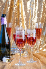 glasses of rose champagne on sparkling golden cloth