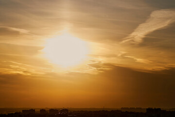 Evening sun in the sunset sky in the light of rays from behind the clouds