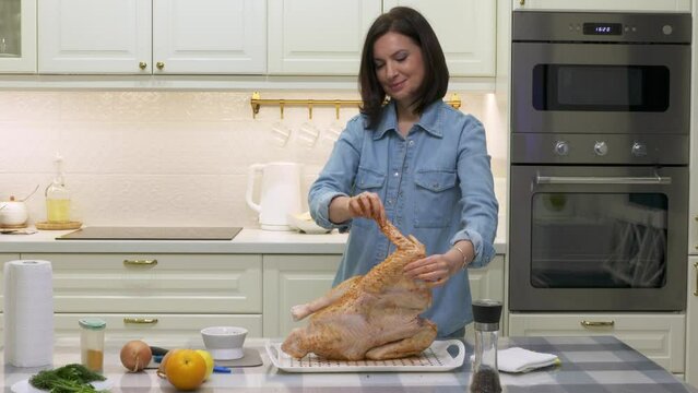woman cooking roasted stuffed turkey in kitchen, thanksgiving and christmas holiday dinner