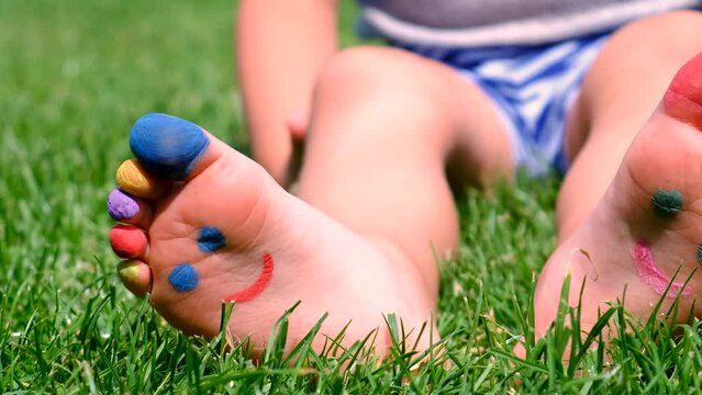 the child's feet are painted on the grass. Selective focus.