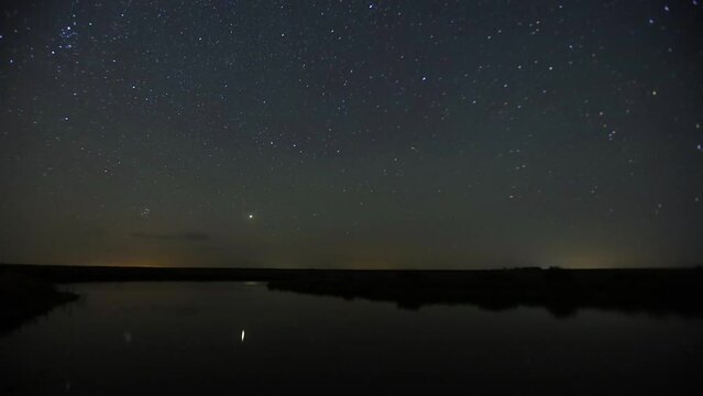 Starry timelapse in the wild above the lake