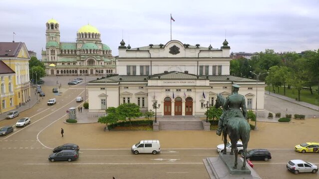 4K. National Assembly of Bulgaria. Aerial view of capital of Bulgaria, Sofia. Flight over the Parliament with a view to cathedral St. Alexander Nevsky. Roofs of buildings, streets and park in Sofia.
