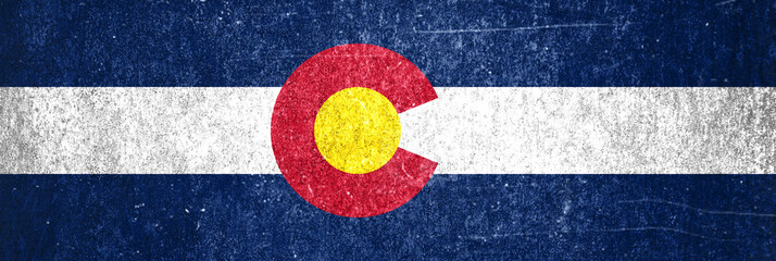 Banner of the grunge Colorado state flag. Dirty Colorado state flag on a metal surface.