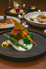 Fotografías de una cena de navidad con elementos navideños como bolas de navidad, pino y velas....