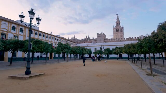 View of the Patio de Banderas courtyard in Seville, Spain. Sspacious square with orange trees, surrounded by historic buildings, offering views of Giralda tower.