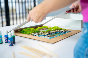 The process of making the art decor of epoxy resin, natural stones and moss