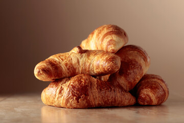 Freshly baked croissants on a beige ceramic table.