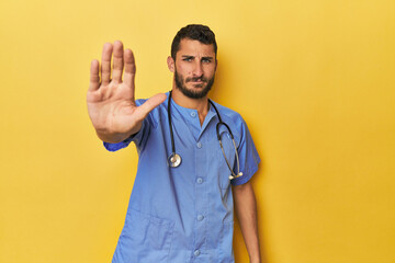 Young Hispanic male nurse Young Hispanic male nurse poses confidently standing with outstretched...