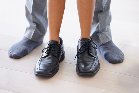 Feet, man and child wearing shoes with dad, getting ready and morning with legs, closeup and socks. Standing, house and childhood for fun, young and bonding together with parent, home and playing