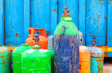 A pile of old used gas cylinders of small size. Scrap metal from gas cylinders.