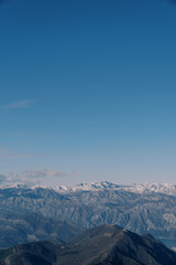 Fototapeta na wymiar Mountain range above the Bay of Kotor against the blue sky in winter. Montenegro