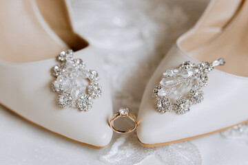 Details of the bride. Beauty is in the details. High-heeled bridal shoes. Gold wedding ring with a...