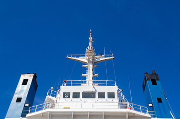 Mast of a cargo ship with navigation equipment bottom view. Radar, signal beeps and signal lights.