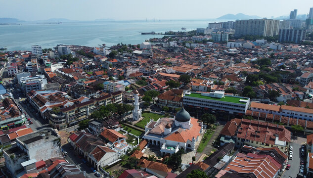 Masjid Kapitan Keling mosque aerial view, built in 19th century by Indian Muslim traders in George Town, Penang, Malaysia. The Malacca strait is seen in the background.