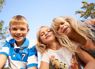 Fototapeta premium Happy children, portrait and playing at park for fun day, holiday or weekend together in nature. Face of young kids or siblings smile for outdoor summer break, bonding or youth on outdoor vacation