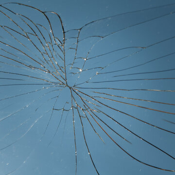 abstract background with broken mirror glass crack reflecting the blue sky