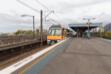Commuter Train fast moving through a Station in Sydney NSW Australia locomotive electric light rail