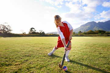 Girl, green grass and playing hockey for sports, game or outdoor match in nature for practice....
