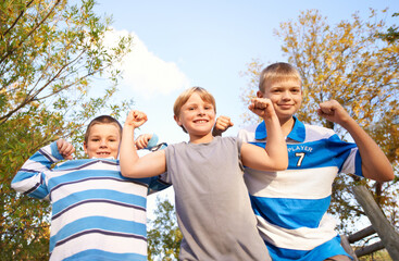 Happy children, portrait and flexing muscles at park for fun day, holiday or weekend together in...