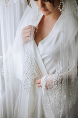 bride in white robe, close-up of hands. Wedding veil. Beauty is in the details. Preparing for the wedding..