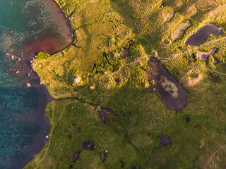 Top view of a lake in mountains, green lands in summer