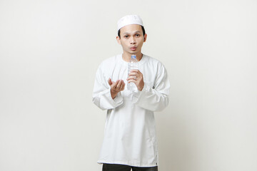 asian muslim man holding water bottle and pray. holding palm face up. People religious Islam lifestyle concept. celebration Ramadan and ied Mubarak. on isolated background.