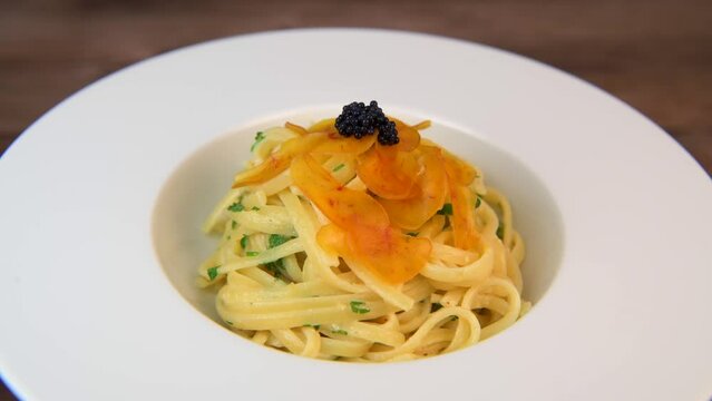 LINGUINE PASTA RECIPE WITH POUTARGUE, LEMON, GARLIC, LEMON ZEST, FRESH CREAM AND PARSLEY. High quality 4k footage
