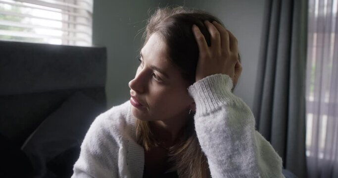 Bedroom, sad woman or thinking of memory with depression, stress or nostalgia in winter in home. Upset face, bored or lonely female person in an apartment to remember past loss, grief or bad history