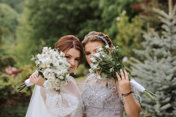 Group portrait of the bride and bridesmaids. A bride in a wedding dress and a bridesmaid in a...