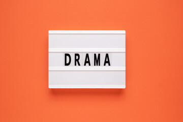 Lightbox with word drama on orange background.