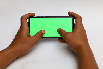 hand holding a computer tablet or smartphone with a blank green screen.
