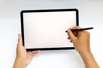 hand holding and using white stylus or pen on digital tablet screen isolated on white background...