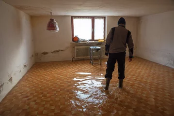 Foto op Aluminium Man walks with rubber boots in a flooded basement room during flood © SusaZoom