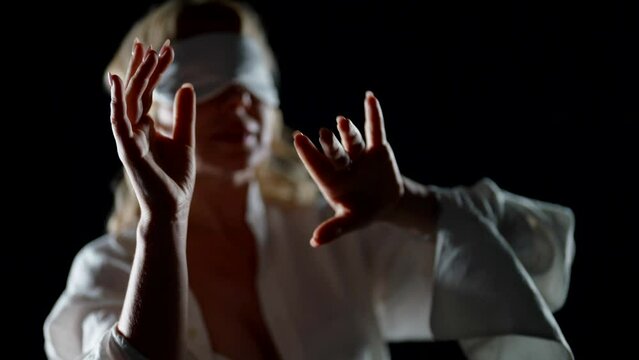 sleepwalking in night, woman in white shirt and sleeping mask on eyes walking in darkness