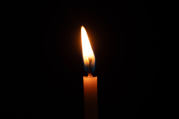 Photograph of candle lights against a black background at night.