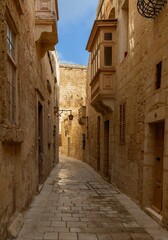 Fototapeta na wymiar typical yellow-ochre limestone buildings in the old town of Mdina in Malta