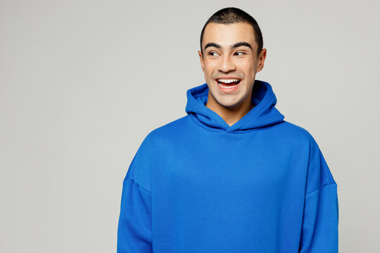 Young surprised happy shocked excited amazed middle eastern man he wear blue hoody casual clothes look aside on empty area isolated on plain solid white background studio portrait. Lifestyle concept.
