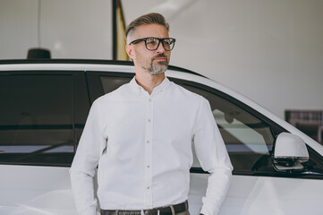 Close up adult serious man customer male buyer client wearing shirt look aside on area choose auto...