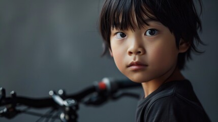 A young boy standing next to a bicycle. Perfect for outdoor activities and childhood memories