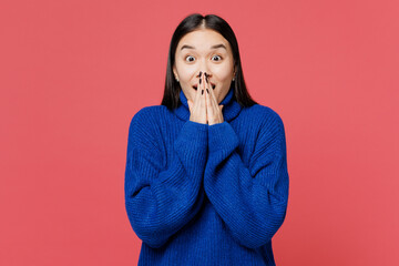 Young surprised astonished shocked woman of Asian ethnicity she wearing blue sweater casual clothes...
