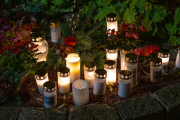 Grave candles on a cemetery on all saints eve.