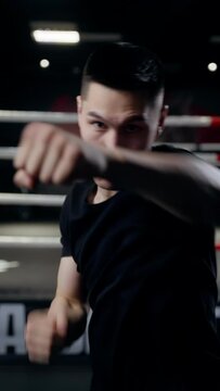 A professional boxer of average build makes punches in the direction of the camera.