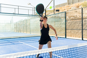 Sporty woman winning a padel tennis match - obrazy, fototapety, plakaty