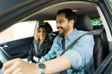 Cheerful happy couple laughing while driving the car