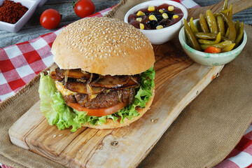 hamburger with cutlet grilled on a wooden surface