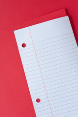 old paper with lines and three-ring binder holes on red