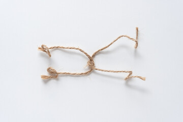 two lengths of twine knotted together and isolated on blank white paper