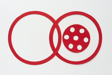 three machine-cut paper shapes (two rings and a circle with decorative spots) on white