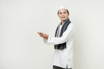 asian muslim man with presenting hand gesture. People religious Islam lifestyle concept. celebration Ramadan and ied Mubarak. on isolated background.