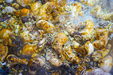 Top view of pieces of chicken that are cooked and boiled with additional seasonings and spices sprinkled on the surface of the meat. Cooked until the spices penetrate inside.